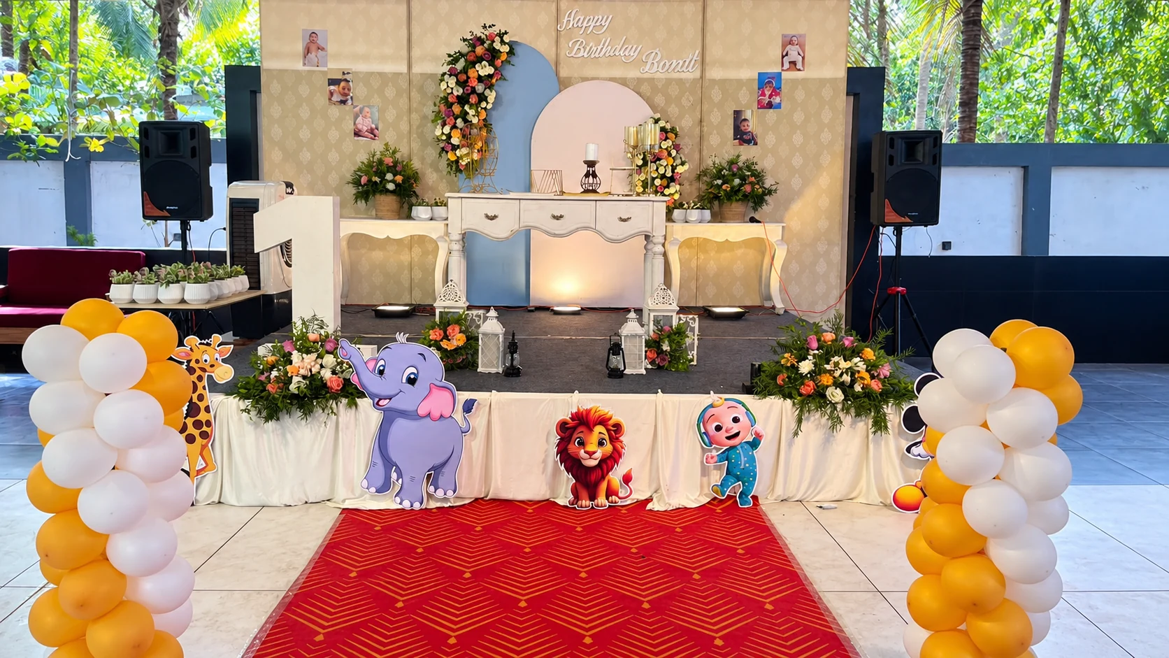 Birthday stage at Avanti Castello with flowers, white and gold balloons and animal decorations